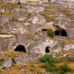 Panorama di un paese abruzzese con grotte storiche, aperte da aprile per visite turistiche.