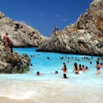 Spiaggia affollata con turisti felici, simbolo della meta vacanziera più popolare dell'anno.