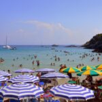 Spiaggia italiana al mare in primavera, ideale per Pasqua 2026, con acque cristalline e poca folla.
