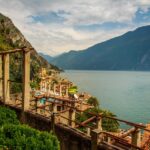 Panorama di un lago italiano in maggio, con vegetazione verde e cielo sereno, ideale per una fuga primaverile.