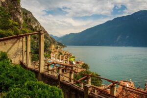 Panorama di un lago italiano in maggio, con vegetazione verde e cielo sereno, ideale per una fuga primaverile.