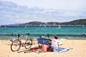 Spiaggia di Sardegna vuota a marzo, con mare calmo e cielo limpido, contrasto con l'affollamento di agosto.